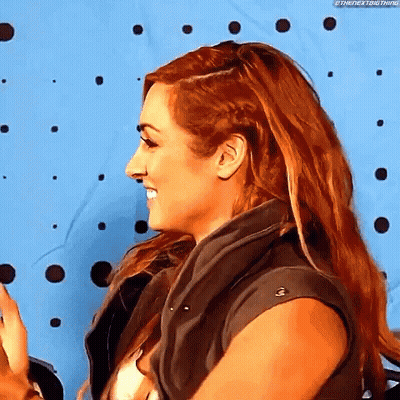 Woman With Long Red Hair Smiling In Vest GIF