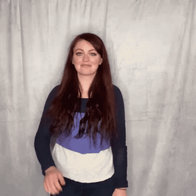 Woman With Long Red Hair Standing In Front Of Curtain GIF