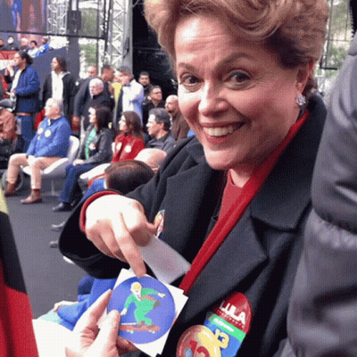 Woman With Lula Sticker On Jacket Smiling GIF