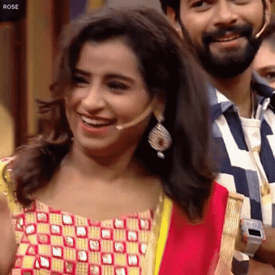 Woman With Microphone Smiling Beside Bearded Man GIF