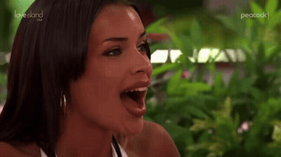 Woman With Mouth Open Sitting By Green Plant GIF