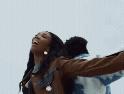 Woman With Necklace And Earrings Beside Man In Blue Jacket GIF