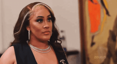 Woman With Necklace And Earrings In Front Of Zeus Ad GIF