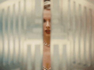Woman With Necklace And Earrings Looking Through Glass Door GIF