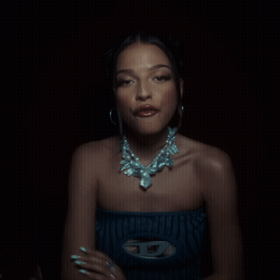 Woman With Necklace And Hoop Earrings Looking At Camera GIF