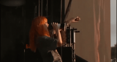 Woman With Orange Hair Singing Into Microphone GIF