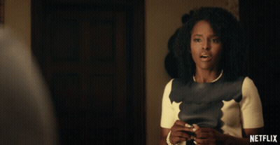 Woman With Pearl Necklace In Front Of Netflix Sign GIF