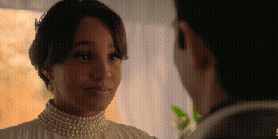 Woman With Pearls Looking At Man GIF