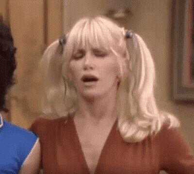 Woman With Pigtails Making Funny Face Next To Man GIF