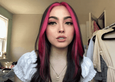 Woman With Pink And Black Hair Wearing Necklace With Letter C GIF