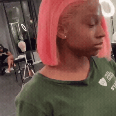 Woman With Pink Hair and Green Shirt Looking at Camera