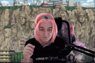 Woman With Pink Hair Sitting At Microphone In Black TRNA Shirt GIF