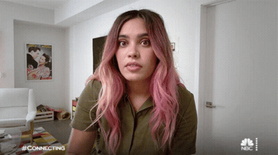 Woman With Pink Hair Sitting In Living Room With NBC Logo GIF