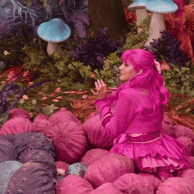 Woman With Pink Hair Sitting In Pink Flowers GIF