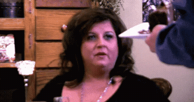 Woman With Plate In Front Of Face GIF