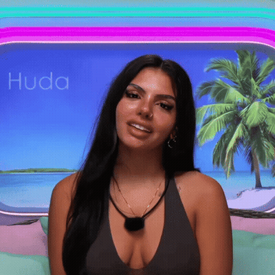 Woman With Plunging Neckline Smiling In Front Of Palm Tree GIF