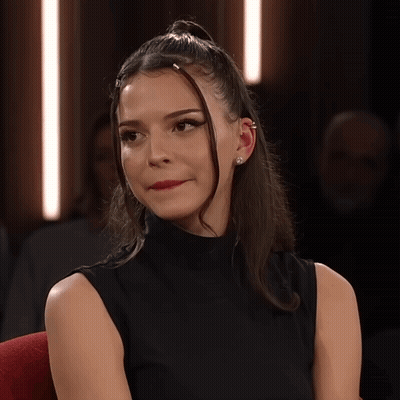 Woman With Ponytail And Ear Piercing Looking At Camera GIF