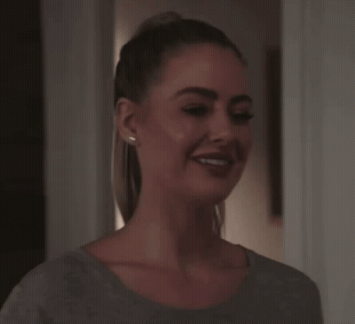 Woman With Ponytail Smiling In Grey Shirt GIF