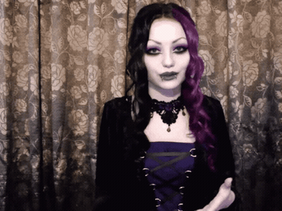 Woman With Purple And Black Hair In Front Of Curtain GIF