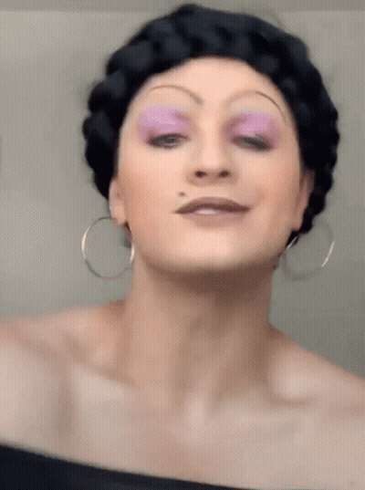 Woman With Purple Eye Shadow And Hoop Earrings GIF