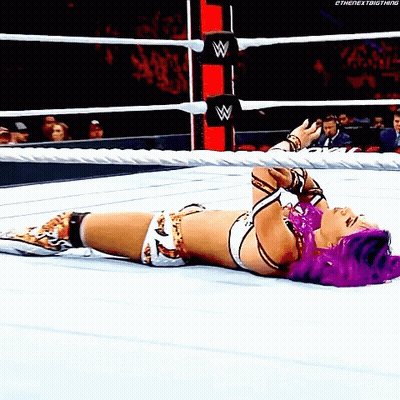 Woman With Purple Hair Laying In Wrestling Ring GIF
