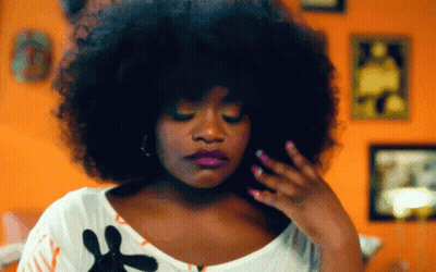 Woman With Purple Lipstick And Pink Nail Polish In Front Of Orange Wall GIF