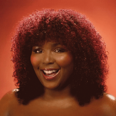 Woman With Red Curly Hair Smiling And Waving GIF