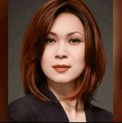 Woman With Red Hair And Black Jacket Looking At Camera GIF