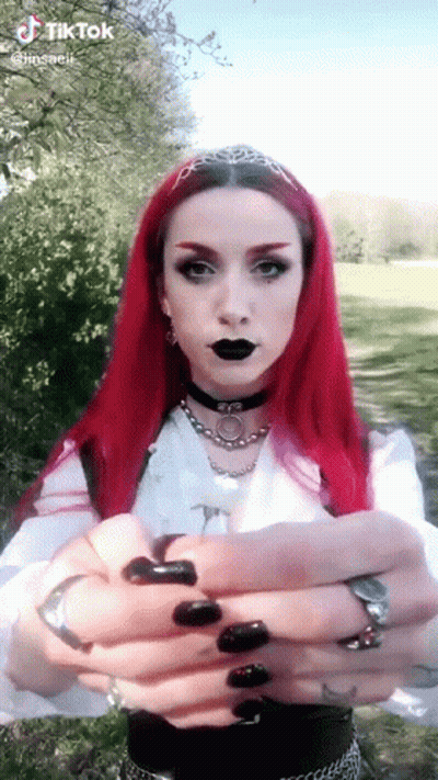 Woman With Red Hair And Black Nails Wearing Choker And White Shirt GIF