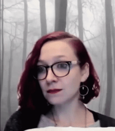 Woman With Red Hair And Glasses Looking At Camera GIF
