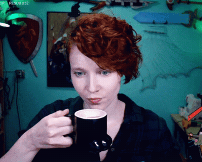 Woman With Red Hair Drinking From Black Mug GIF
