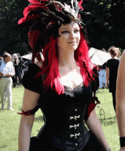 Woman With Red Hair In Black Corset And Feathered Headdress GIF