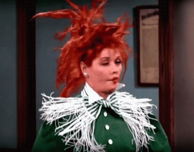 Woman With Red Hair In Green Jacket And White Feather Collar GIF