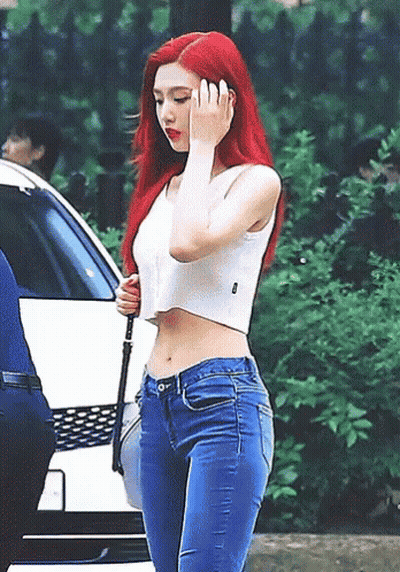 Woman With Red Hair In White Crop Top And Blue Jeans GIF