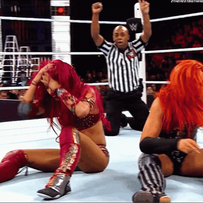 Woman With Red Hair Kneeling In Wrestling Ring With Referee GIF