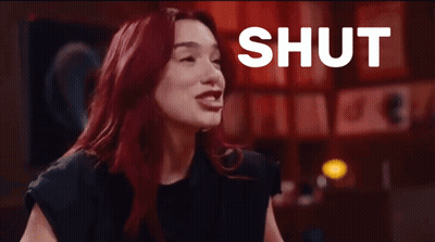 Woman With Red Hair Laughing At Shut Up Sign GIF