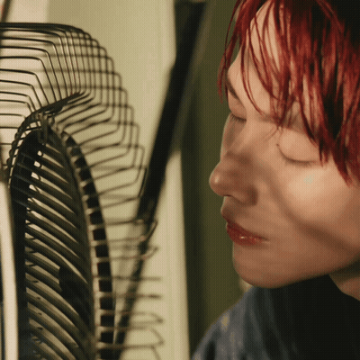 Woman With Red Hair Looking At Fan GIF