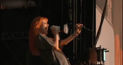 Woman With Red Hair Singing Into Microphone GIF