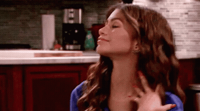 Woman With Red Nails Sitting In Kitchen Hand On Neck GIF