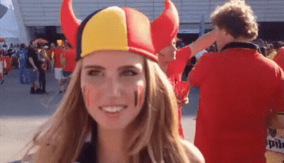 Woman With Red, Yellow, And Black Horned Hat GIF