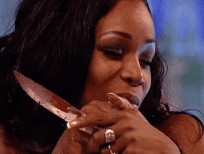 Woman With Ring Holding Knife In Mouth GIF