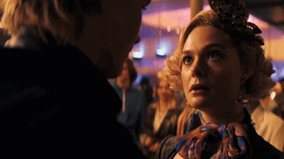 Woman With Scarf Looking At Man In Crowd GIF