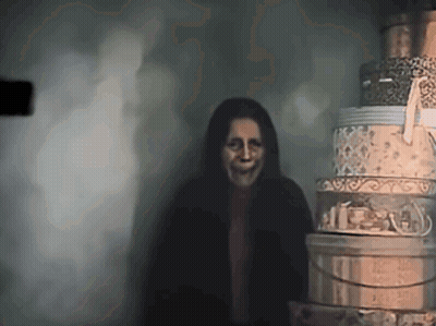 Woman With Scary Face Next To Stack Of Boxes GIF