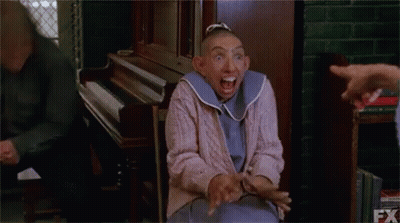Woman With Shaved Head Making Funny Face At Piano GIF