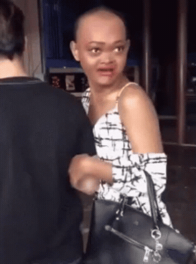 Woman With Shaved Head Standing Next To Man Holding Purse GIF