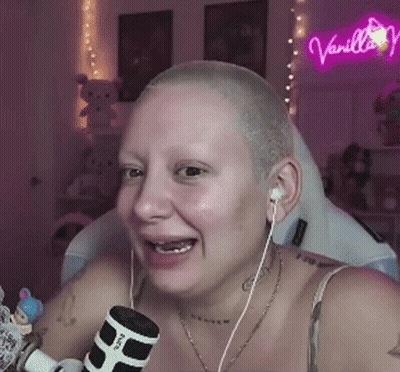 Woman With Shaved Head Wearing Earbuds Holding Microphone GIF