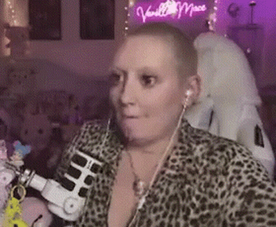 Woman With Shaved Head Wearing Headphones And Leopard Print Shirt GIF