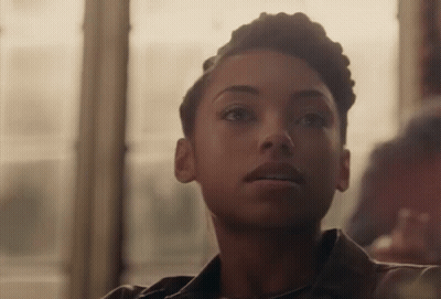 Woman With Short Hair Sitting In Front Of Window Looking At Camera GIF