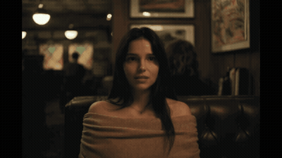 Woman With Sweater On Shoulders In Dark Room GIF