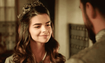 Woman With Tiara Looks At Bearded Man GIF